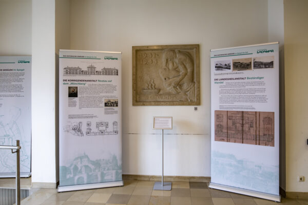 Two roll-up displays with texts and images are located in an entrance area.